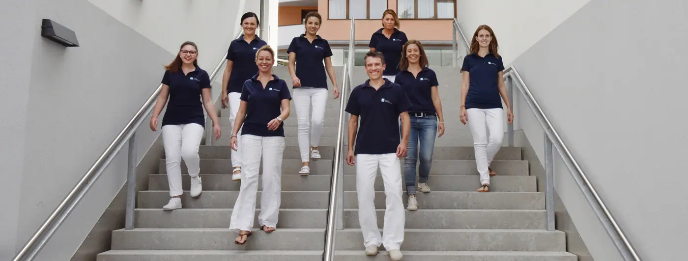 Das Praxisteam auf der Treppe vor der Praxis